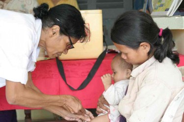 Une infirmière vaccine un bébé dans une clinique communautaire. Les outils InSTEDD sont utilisés dans cette clinique afin de fournir une assistance dans la gestion des ressources et la surveillance des maladies.