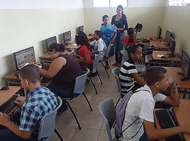 A group of young people in a community technology center in Cutupú, Dominican Republic learning how to read books online. Photo from @CTCCutupu Twitter account.